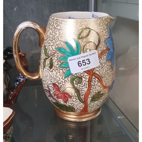 653 - A Moorcroft pottery jug decorated with flowers.