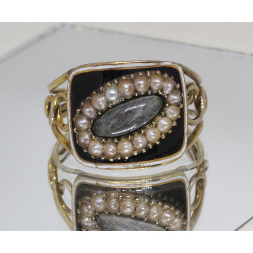 4 - A Georgian black enamel and split pearl mourning ring, central oval hair panel surrounded by sevente... 