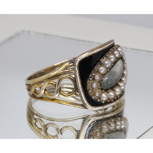 4 - A Georgian black enamel and split pearl mourning ring, central oval hair panel surrounded by sevente... 