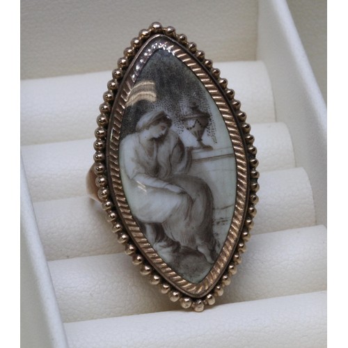 3 - A Georgian mourning ring, the navette shaped ivory panel painted en grisaille depicting a lady seate... 