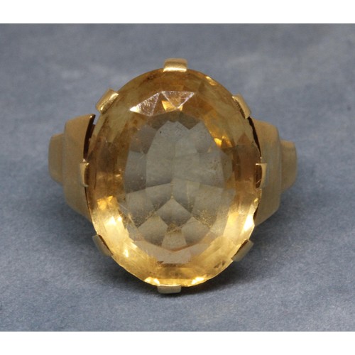 26 - An Art Deco style citrine ring, the central oval mixed cut stone weighing approx. 13cts, band indist... 