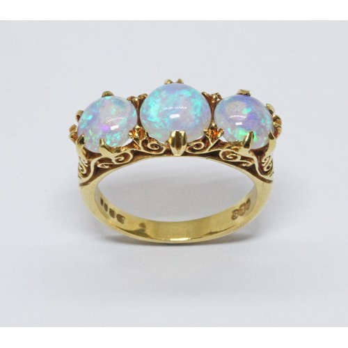 102 - A three stone opal ring, scroll setting with three round opal cabochons, hallmarked 18ct gold, spons... 