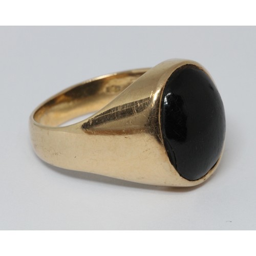 133 - A signet ring set with a black cabochon marked '750', gross weight 11.2g, size T/U.