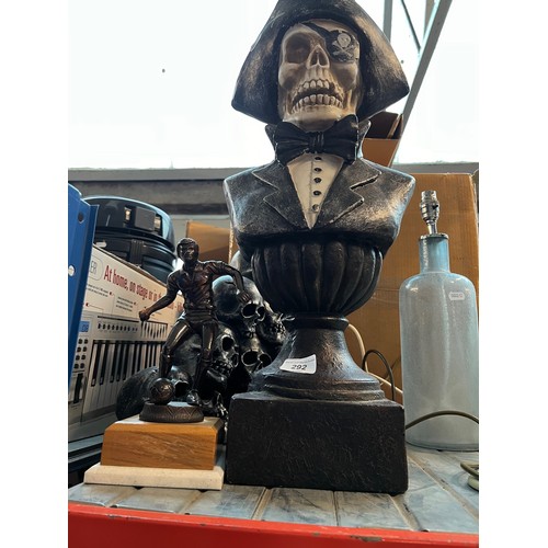 292 - A bust of a skeleton pirate together with skulls ornament and a cast metal football trophy