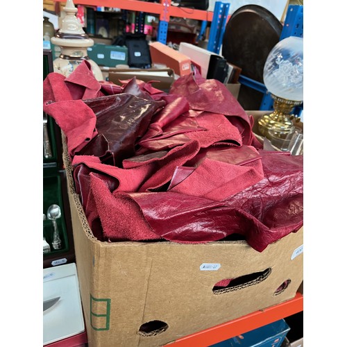 400 - A box of red leather offcuts and cushion covers.