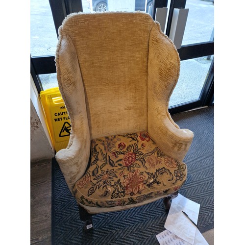 885 - A George I walnut framed wingback armchair with shell carved knees.