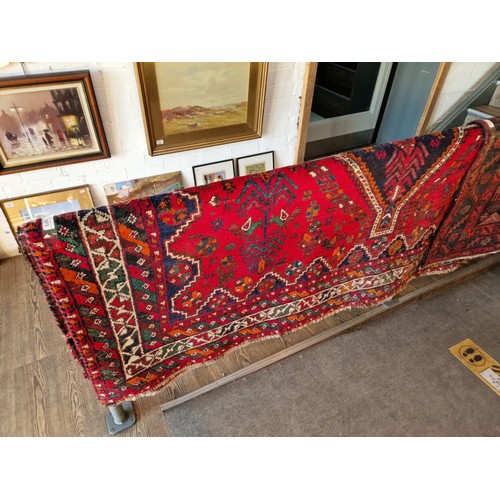 1073 - A vintage Middle Eastern hand knotted carpet, red ground, appx 290cm x 219cm