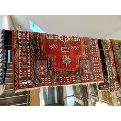 1076 - A Middle Eastern silk carpet, red ground, 136cm x 105cm.