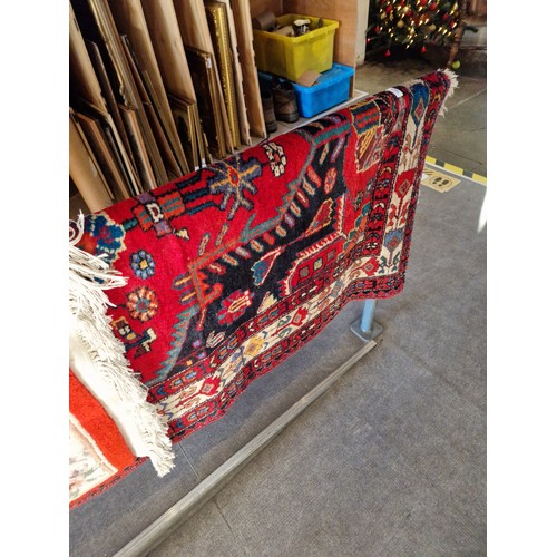 1069 - A vintage Eastern hand knotted wool carpet, red ground, 203cm x 133cm appx