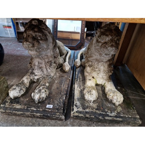 1095 - Two large stoneware recumbent lion garden ornaments.