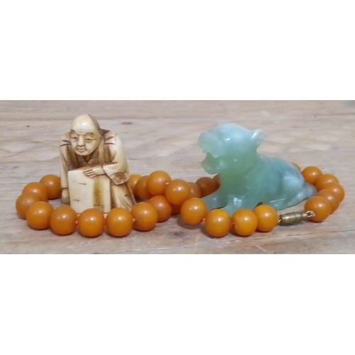 339 - A bone netsuke, a jadeite jad carving and a bead necklace.