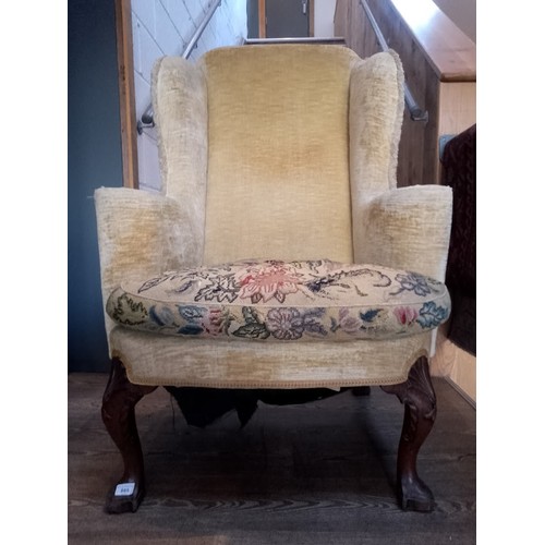 885 - A George I walnut framed wingback armchair with shell carved knees.