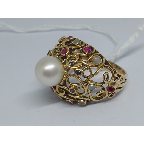 24 - A multi-gem set ring, set with a central cultured pearl, further cultured pearls, rubies and sapphir... 