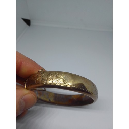 69 - A hallmarked 9ct gold bangle, diameter 58mm, weight 19.4g.