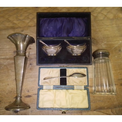 121 - A mixed lot of hallmarked silver comprising a cased pair of salts, a vase, a cased spoon and a sugar... 