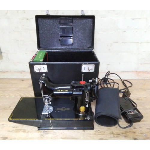 140 - A Singer Featherweight 221K electric travel sewing machine with case and accessories.