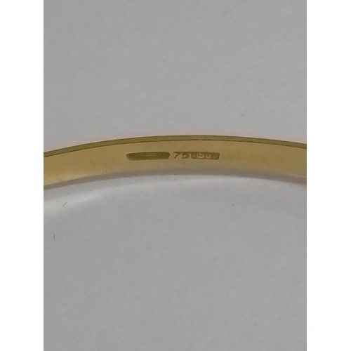 34 - An eastern yellow metal bangle, marked '750' also with Italian marked, diameter approximately 7cm, w... 