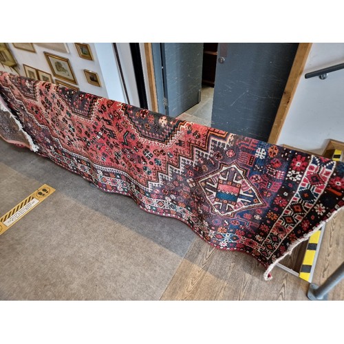 903 - A vintage Middle Eastern hand knotted wool carpet, red ground, 282cm x 202cm (approx)