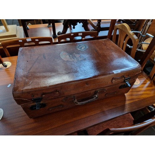 932 - A vintage brown leather travel case bearing various old travel labels including Cunard White Star, e... 