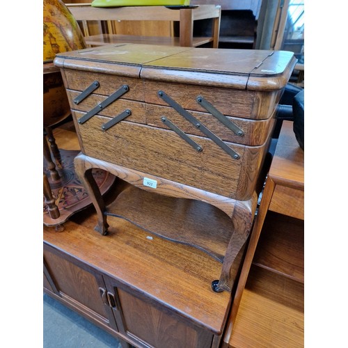 922 - A vintage oak cantilever sewing box containing various needles, threads, buttons and accessories.