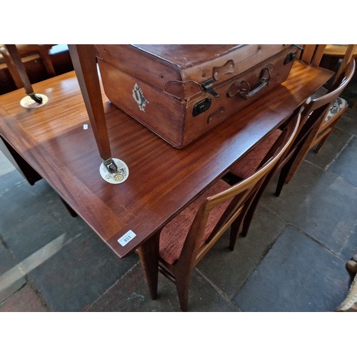 933 - A mid 20th century extending teak dining table and four chairs.