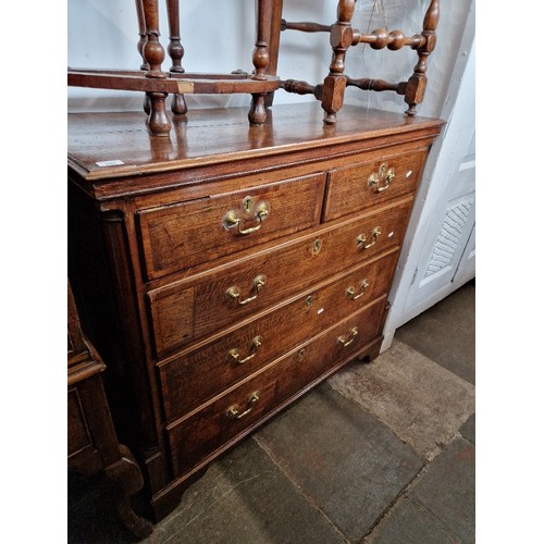 943 - A George III oak chest of drawers, standing on bracket feet.