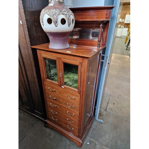 951 - An Edwardian inlaid mahogany music cabinet.