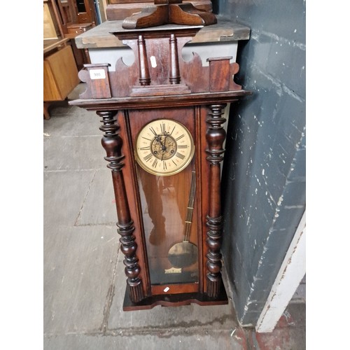 980 - A mahogany cased Vienna wall clock with pendulum and key.