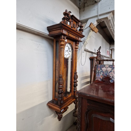 998 - A walnut cased Vienna wall clock with pendulum and key.