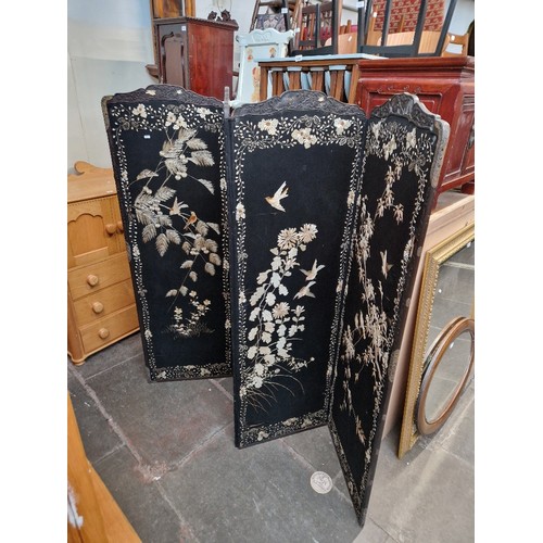 1009 - A Chinese four panel folding screen decorated with birds and flowers.