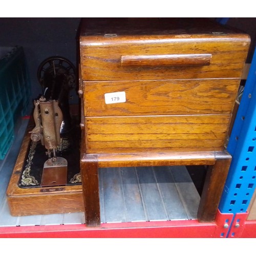 179 - A Singer hand crank sewing machine together with a cantilever sewing box containing various items.