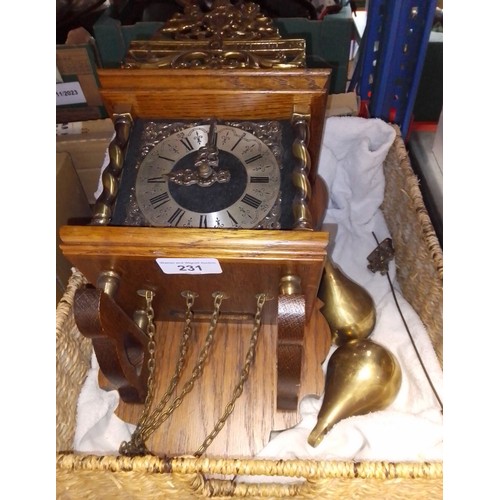 231 - A vintage wall clock with brass weights and pendulum.