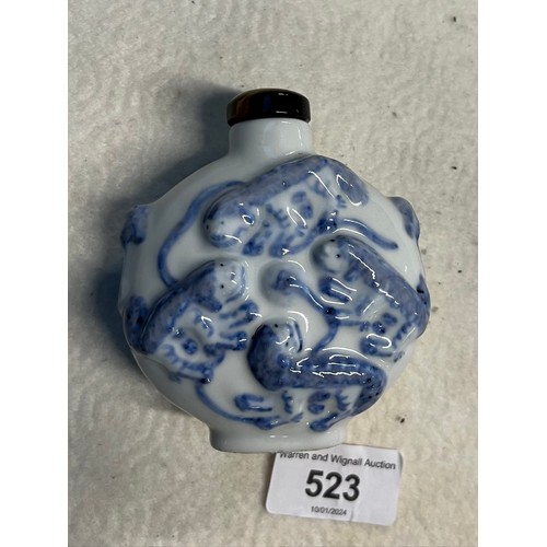 523 - A Chinese porcelain snuff bottle, embossed with foh dogs, tiger's eye top, Guangxu six character mar... 