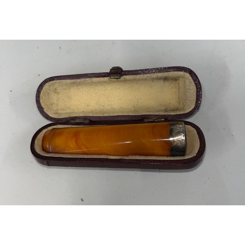 476 - An amber cheroot holder with hallmarked silver band, in original case, length appx 7cm