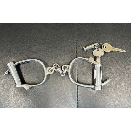 493 - A pair of chrome plated Hiatt handcuffs with key