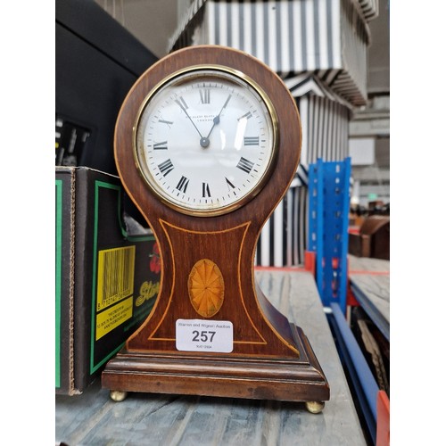 257 - An inlaid mahogany balloon mantel clock.