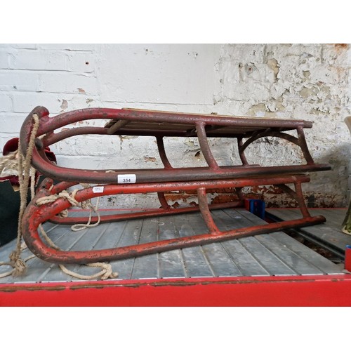 354 - Two vintage sledges, wood seats and metal runners.