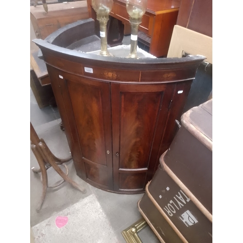 1025 - A Georgian inlaid mahogany corner cabinet.