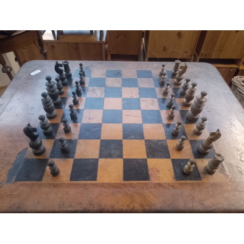 1022 - A Victorian walnut chess table with pieces.