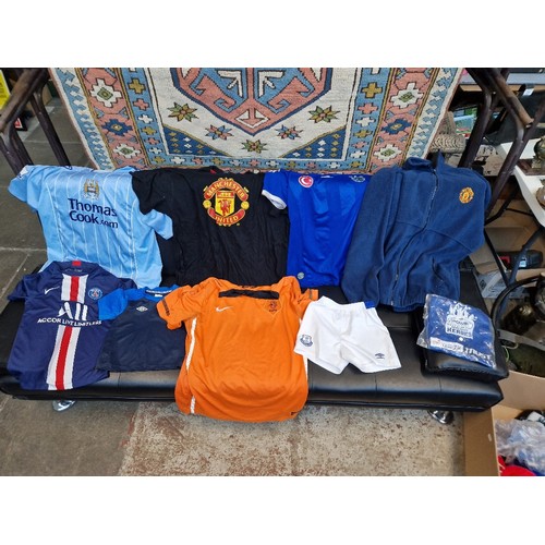 267 - A box of mixed football shirts, shorts, scarves and a Man United fleece.