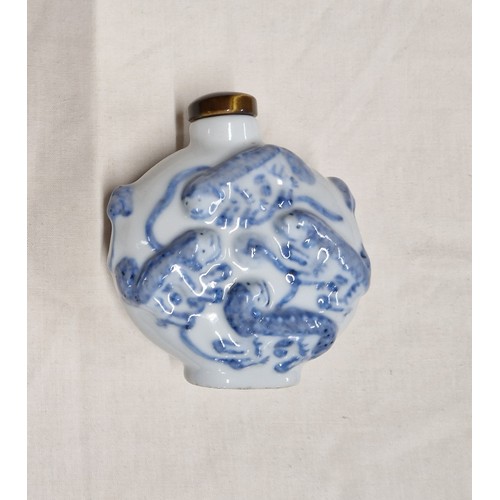 523 - A Chinese porcelain snuff bottle, embossed with foh dogs, tiger's eye top, Guangxu six character mar... 