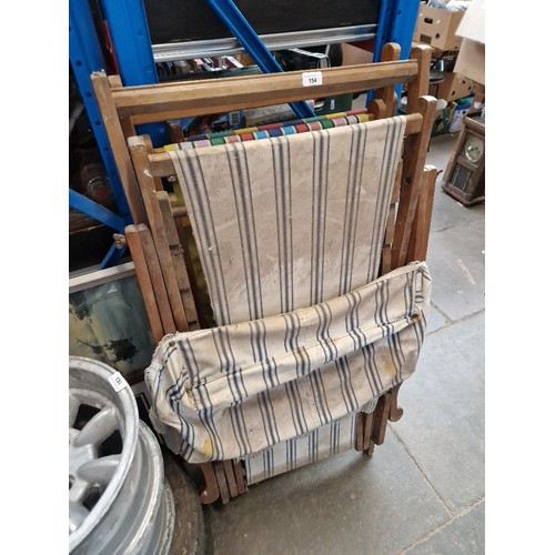 154 - Two canvas deck chairs and one vintage deck chair complete with sun shade and foot rest.