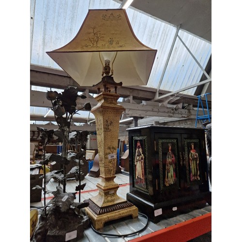 206 - A lacquered cabinet, a metal centrepiece and a Pagoda style table lamp.