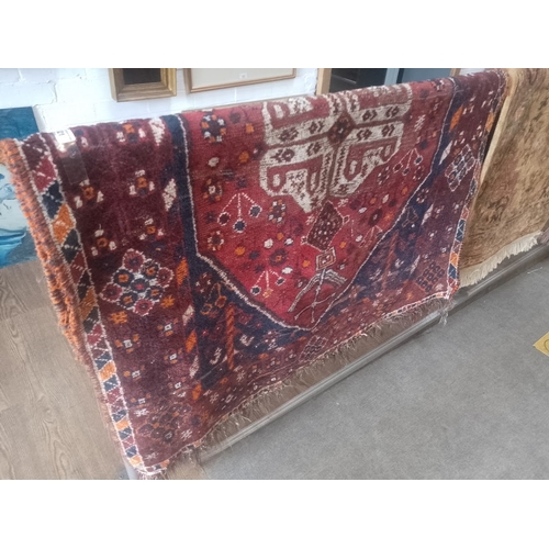 821 - A vintage Middle Eastern hand knotted wool carpet, red ground, 165cm x 116cm (approx).