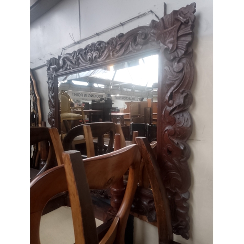 845 - An Edwardian Arts & Crafts carved oak framed mirror.