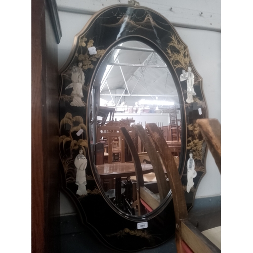 846 - A Chinese black lacquer and gilt decorated mirror with mother of pearl relief figures.