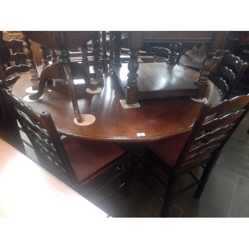 869 - An aged oak dining table and six chairs.