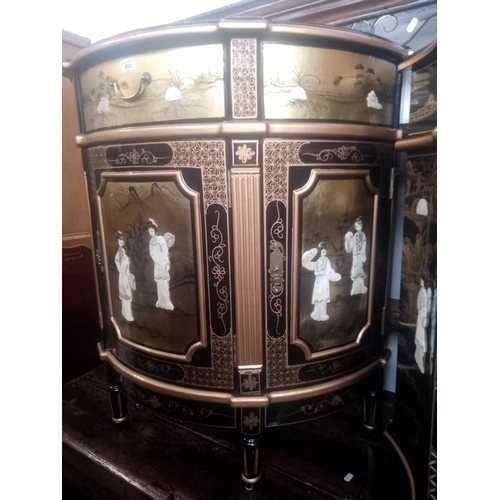 893 - A Chinese black lacquer and gilt decorated demi-lune side cabinet with mother of pearl figures.