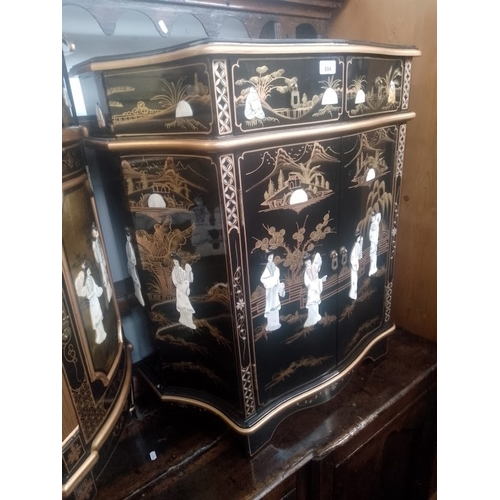 894 - A Chinese black lacquer and gilt decorated side cabinet with mother of pearl relief figures.