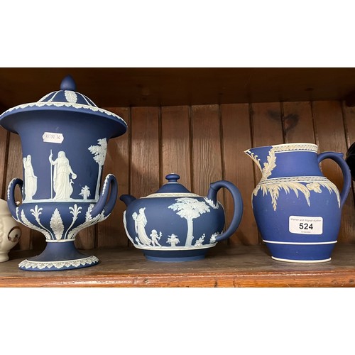 524 - Three pieces of Wedgwood jasper ware in dark blue - lidded, twin handled urn, teapot, and tall jug w... 